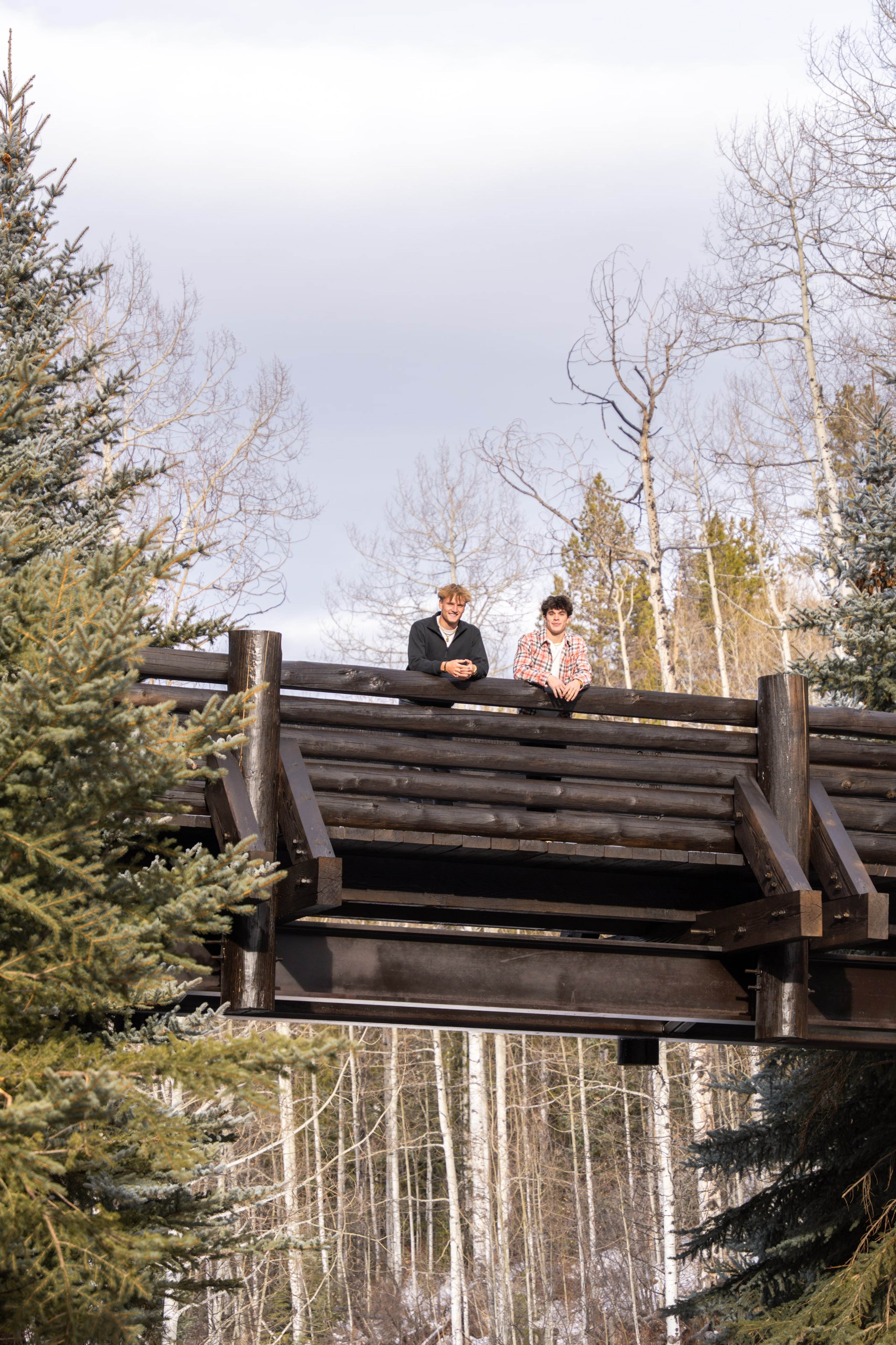 Jakob and Ryder sitting on a timber bridge above the trail