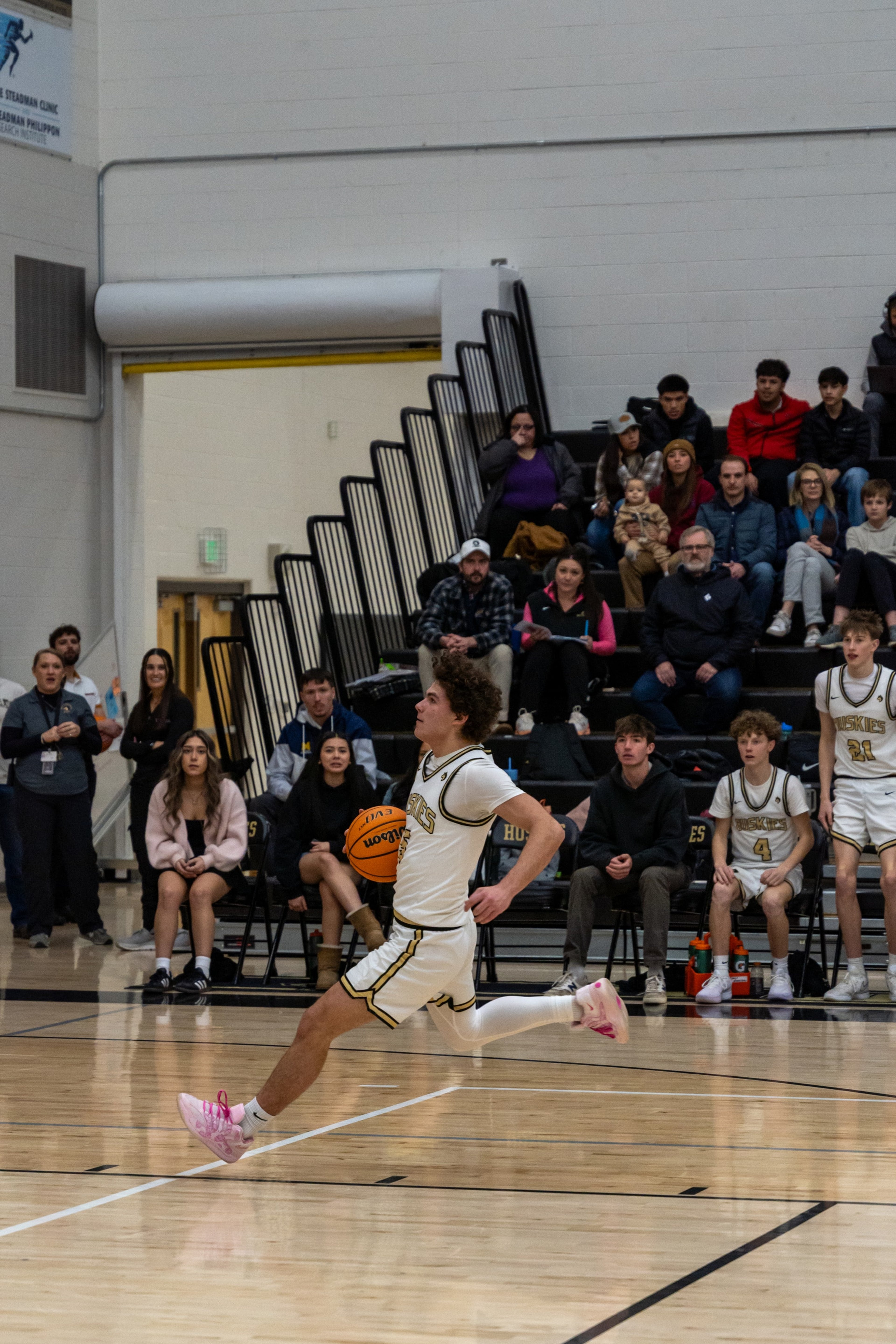 A player in pink shoes accelerates along the baseline