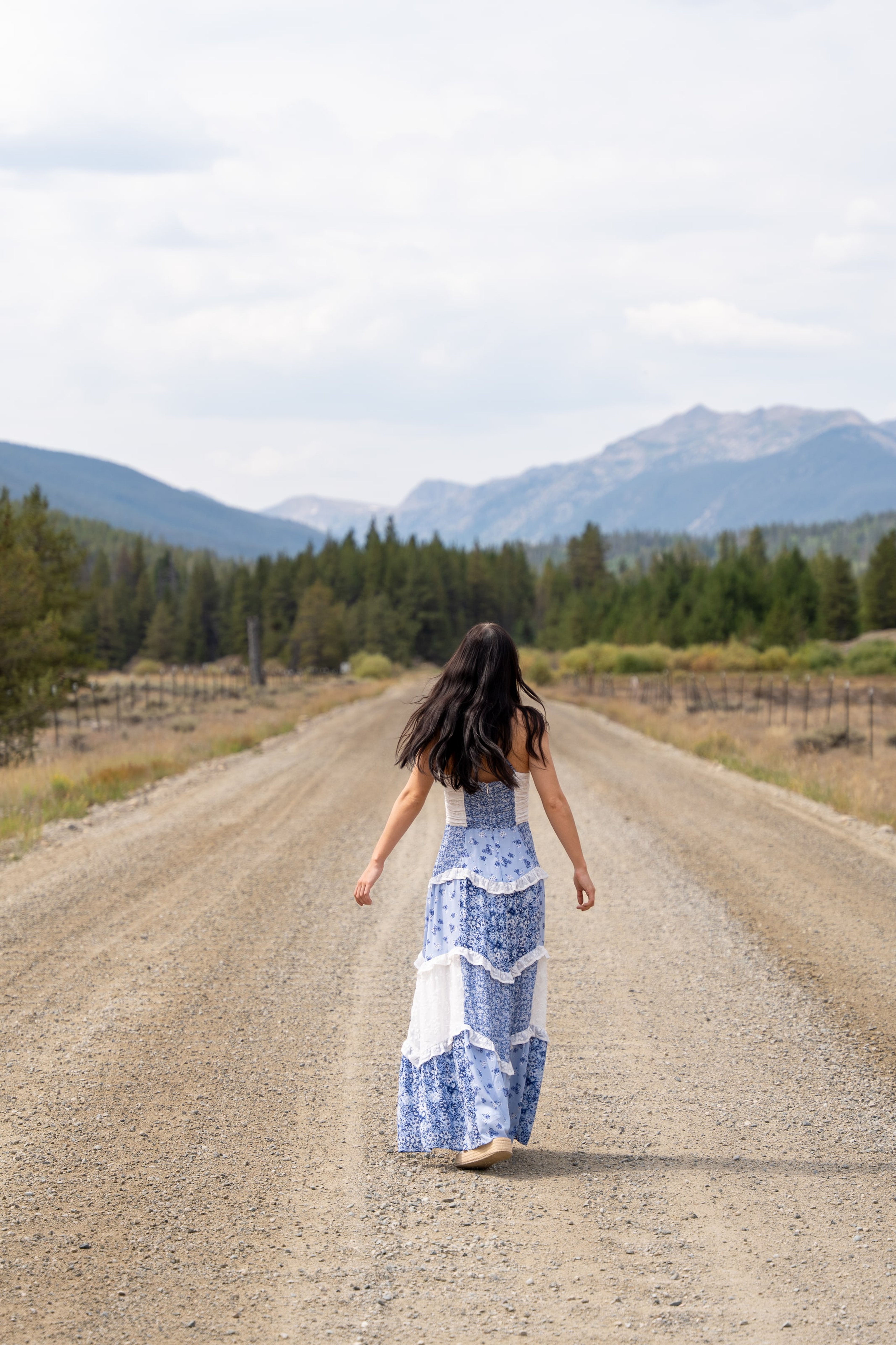 Lucy walking away down a gravel road toward the mountains