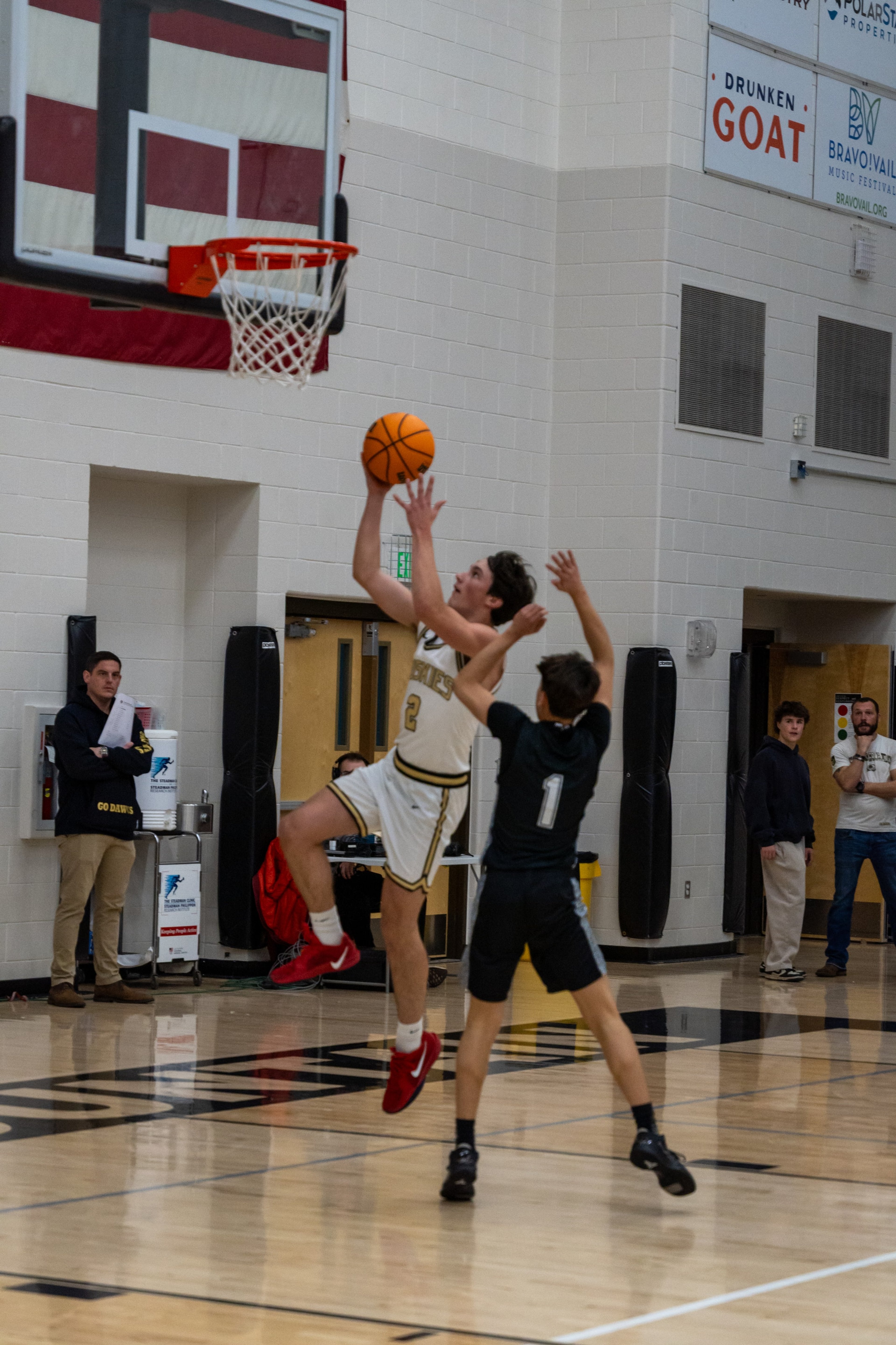 A Huskies player rises for a contested layup