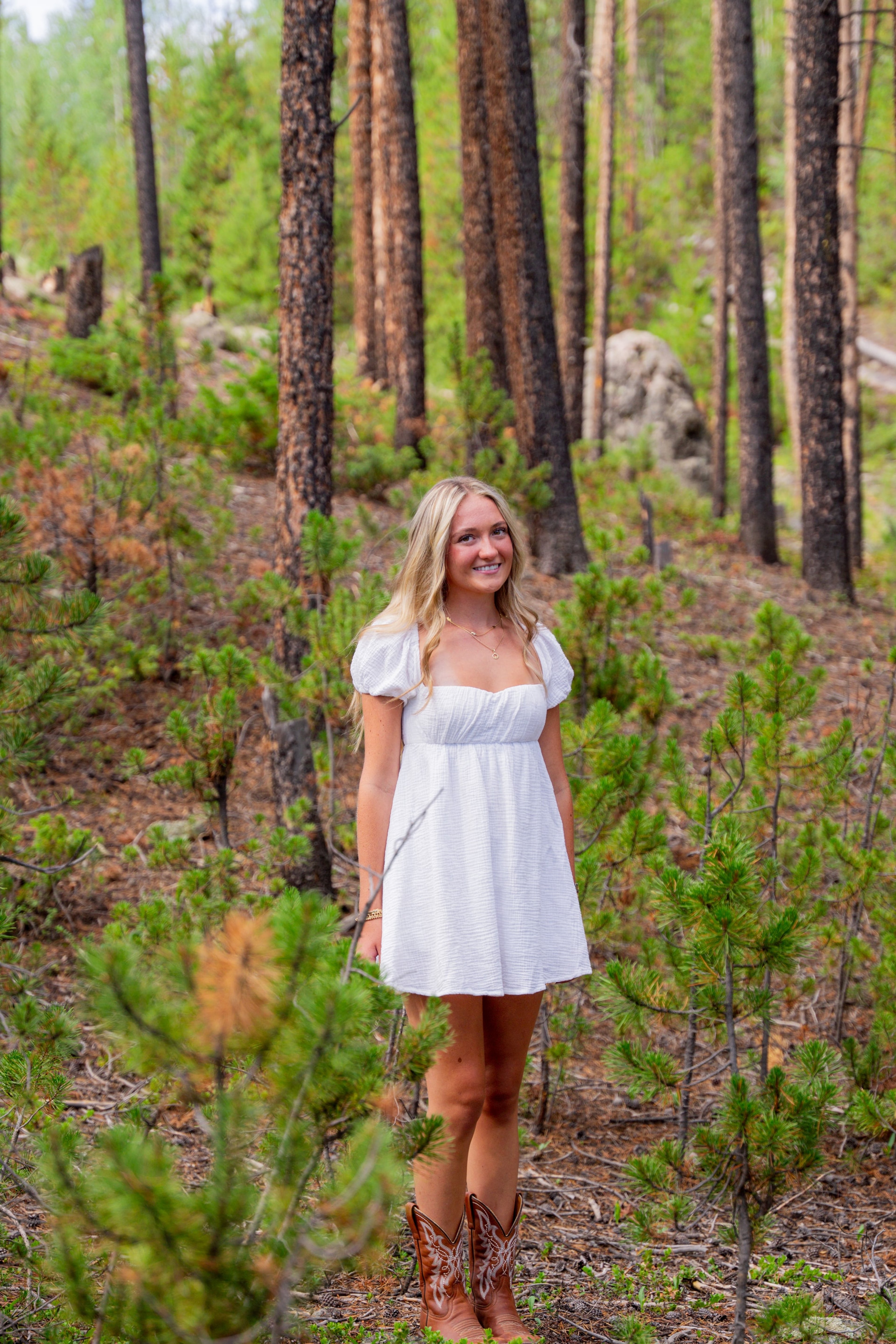 Caleigh smiling on a green woodland path
