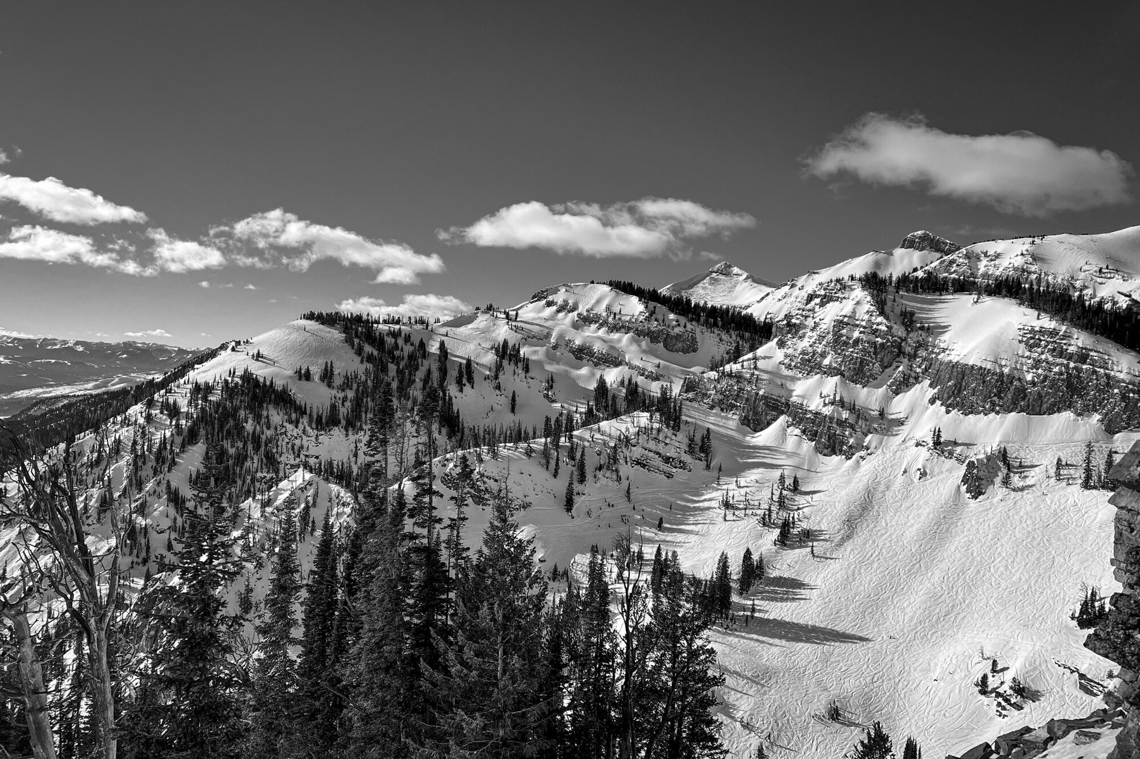 Wind-carved snow ridges descending into a Jackson Hole bowl, in black and white