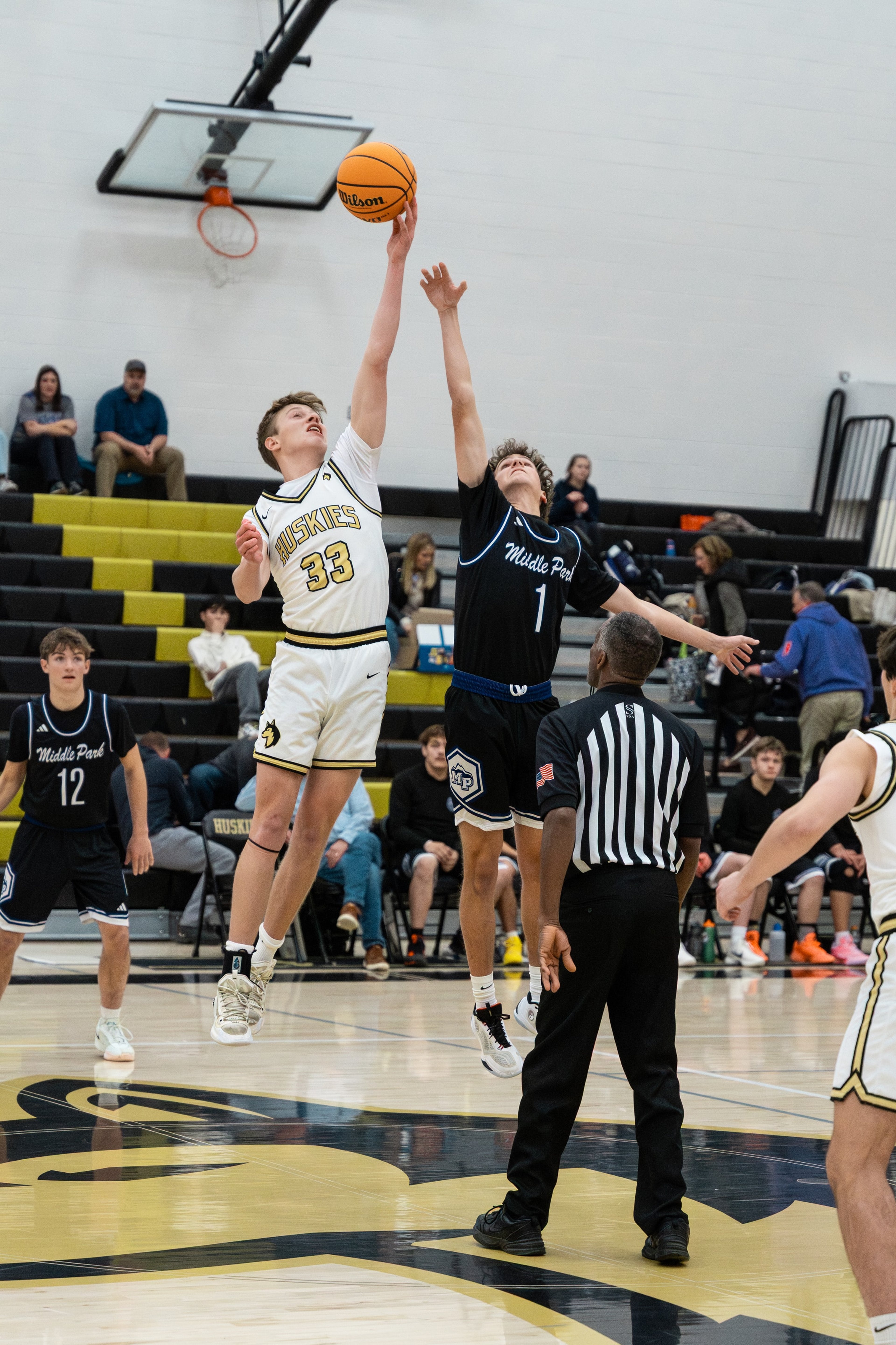 Two basketball players rise for the opening tip