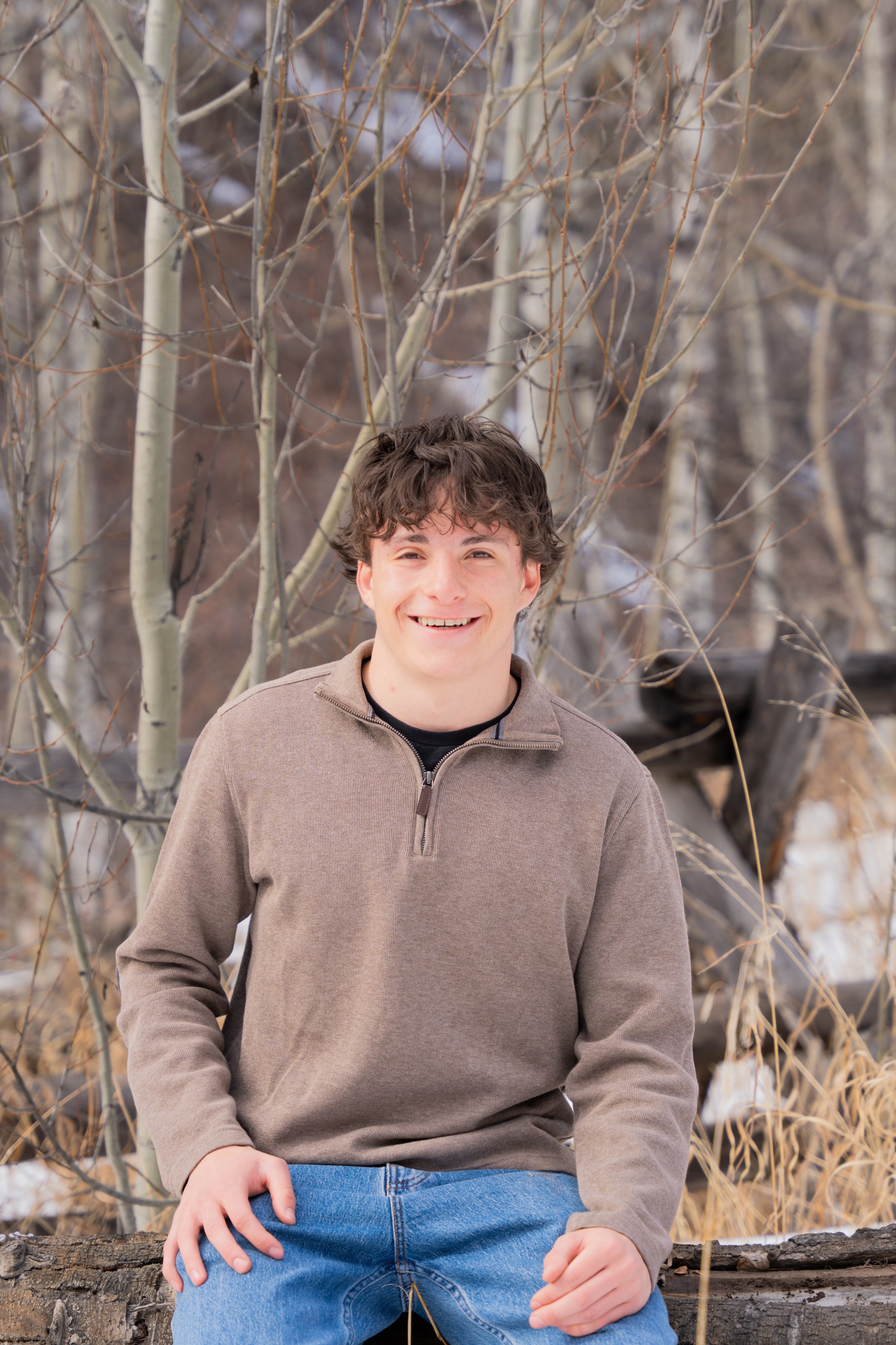 Luca seated in winter grass, laughing