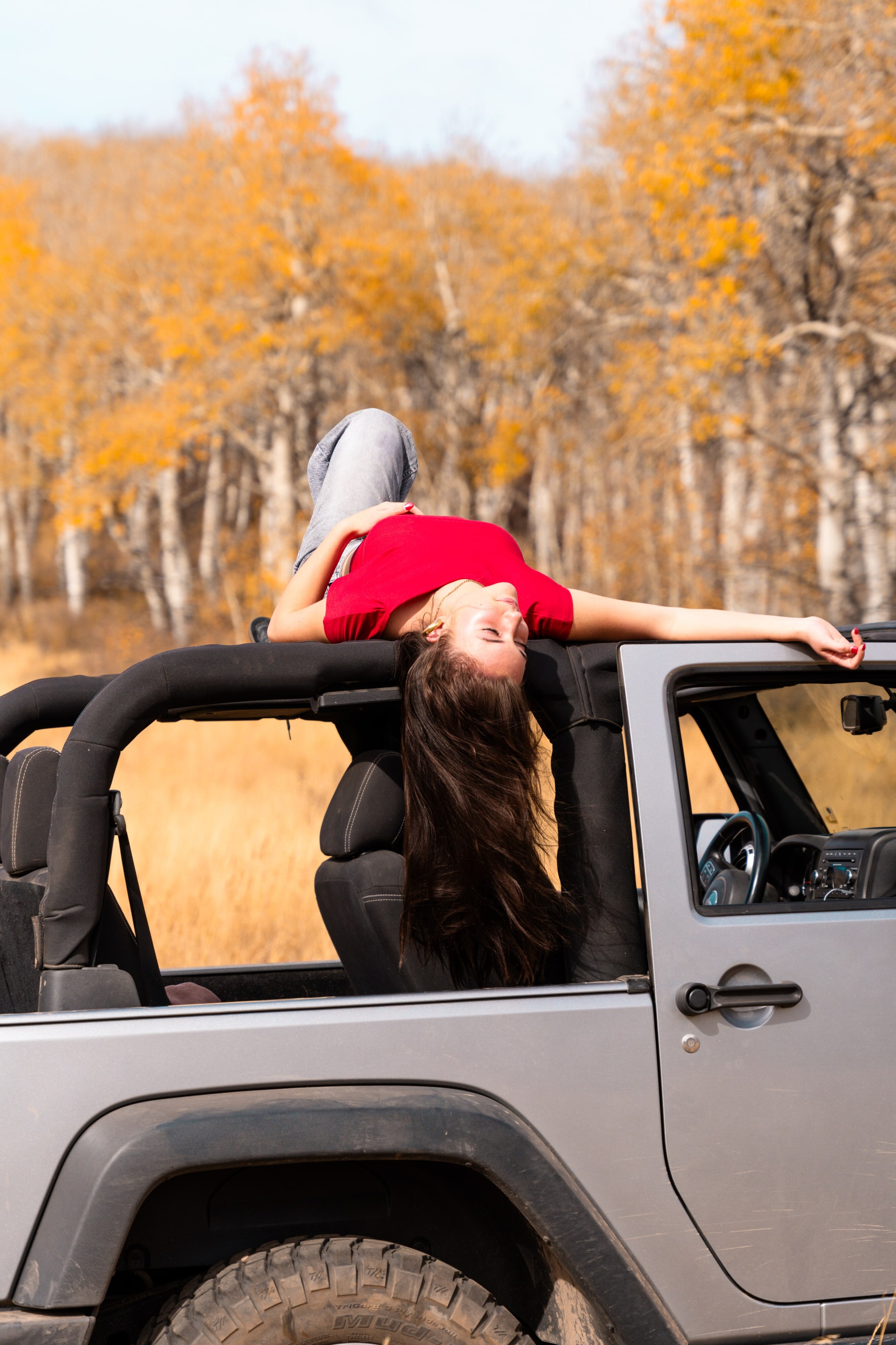 Lucy lying back across the Jeep's windshield, arm thrown wide
