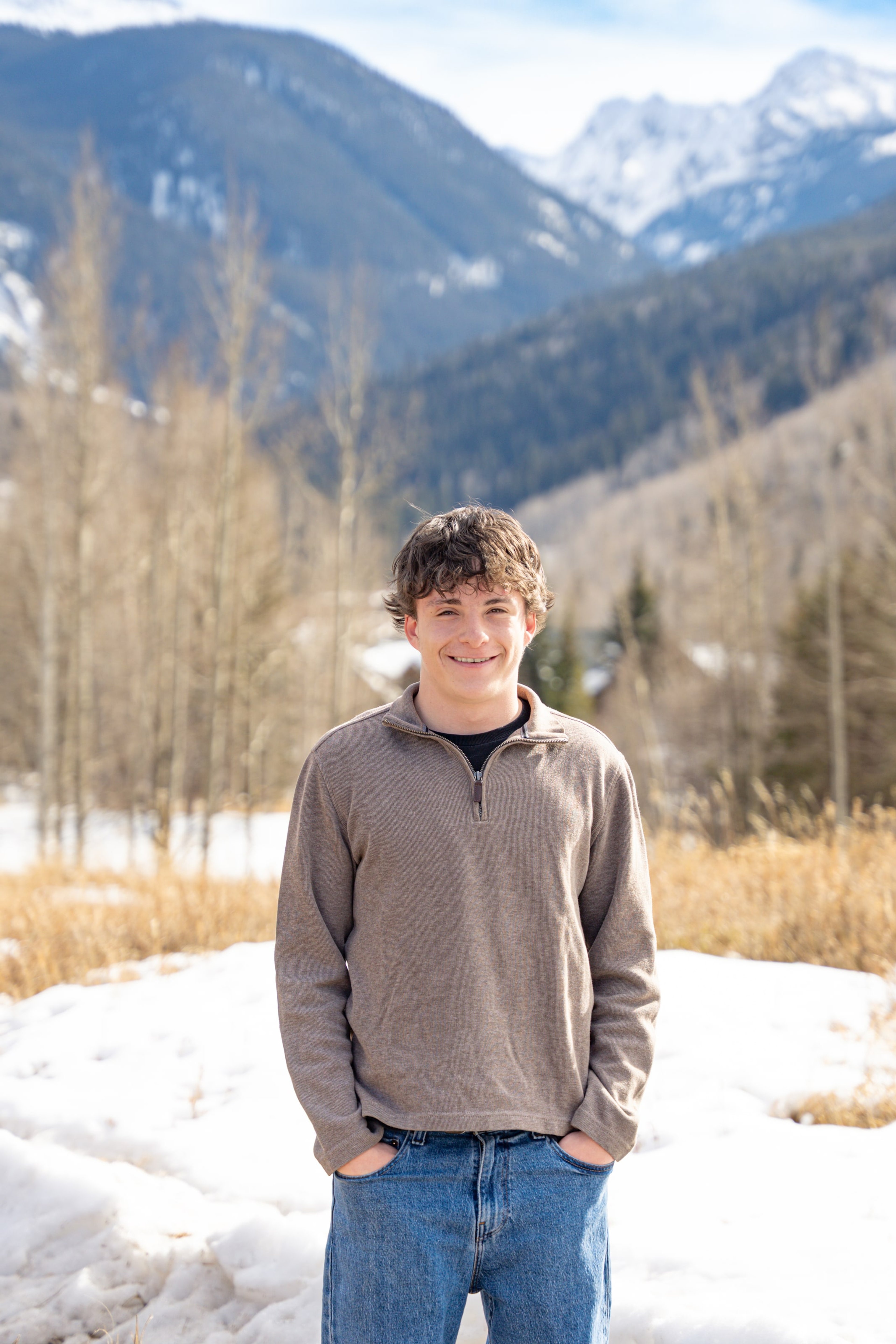 Luca with hands in pockets among winter aspens