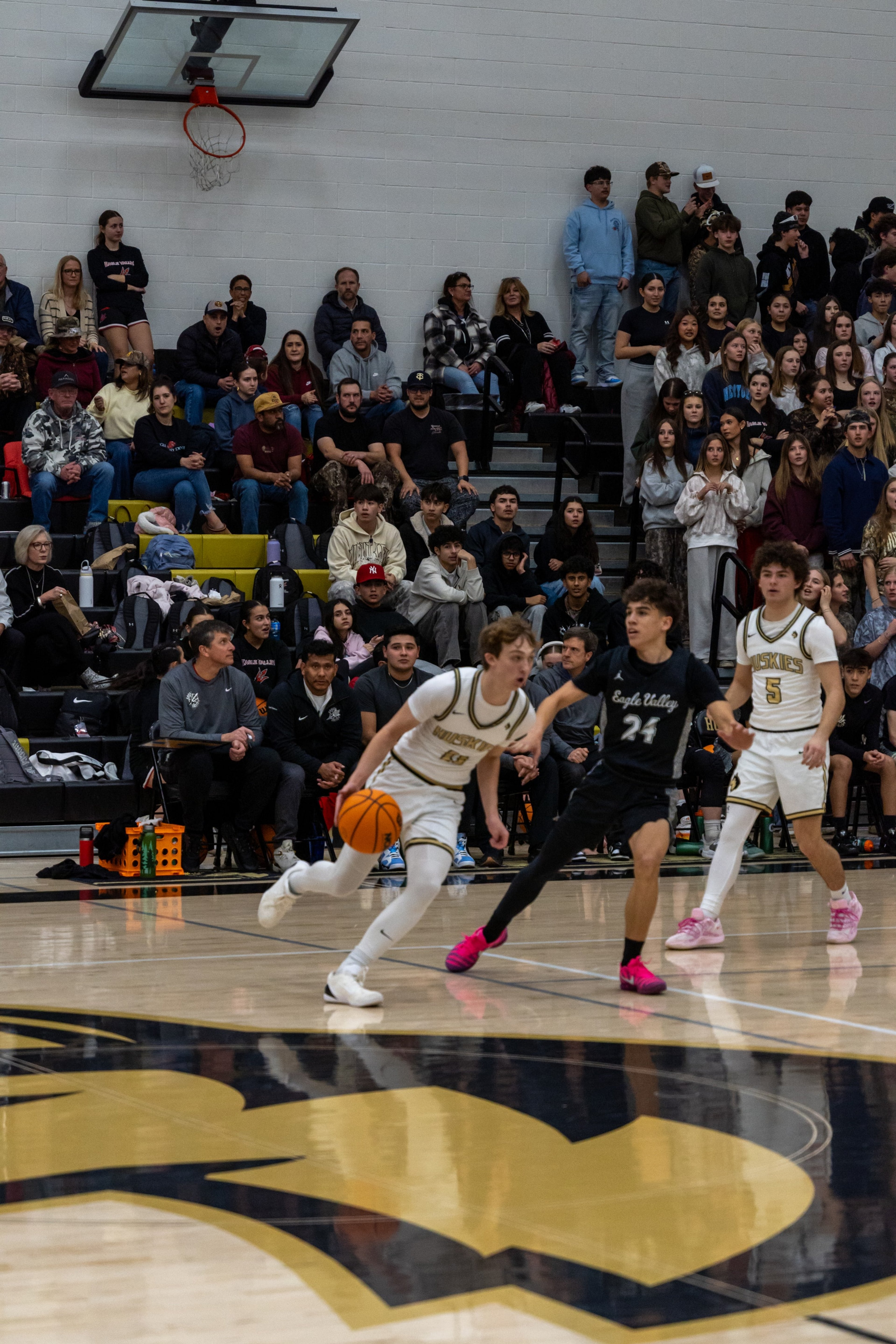 A ball handler drives past a defender at center court