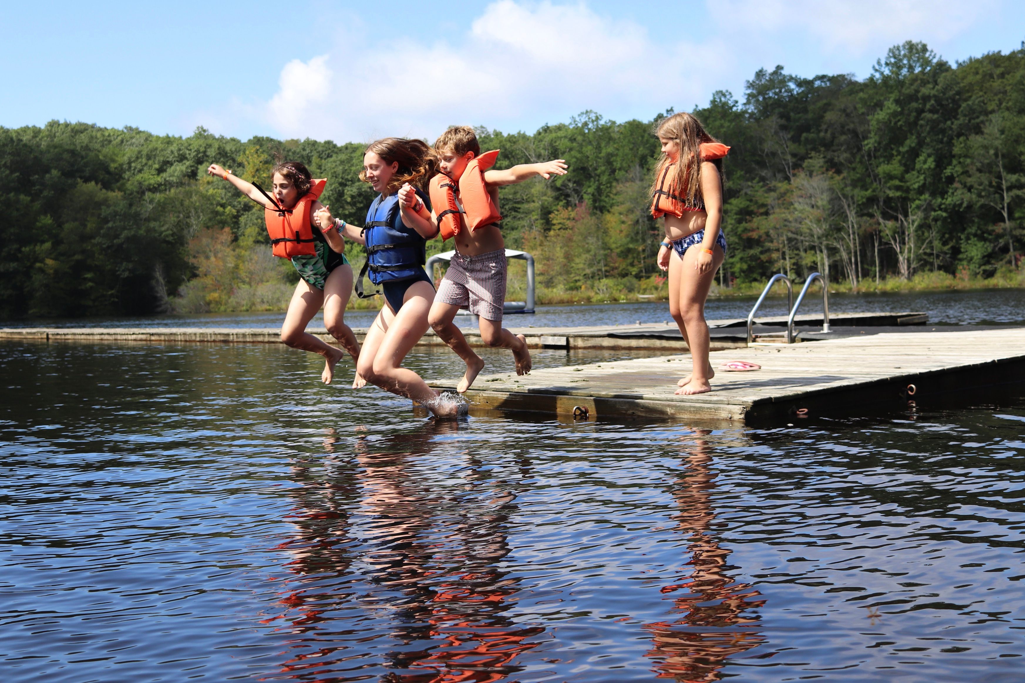 campers jumping in the lake