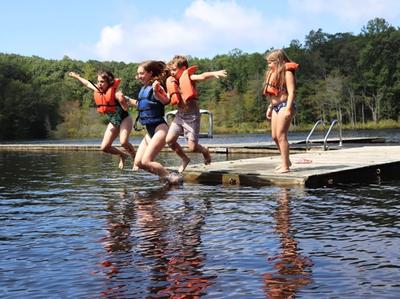 campers jumping in the lake