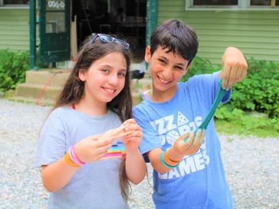 two smiling campers playing with silly putty at Camp Laurelwood
