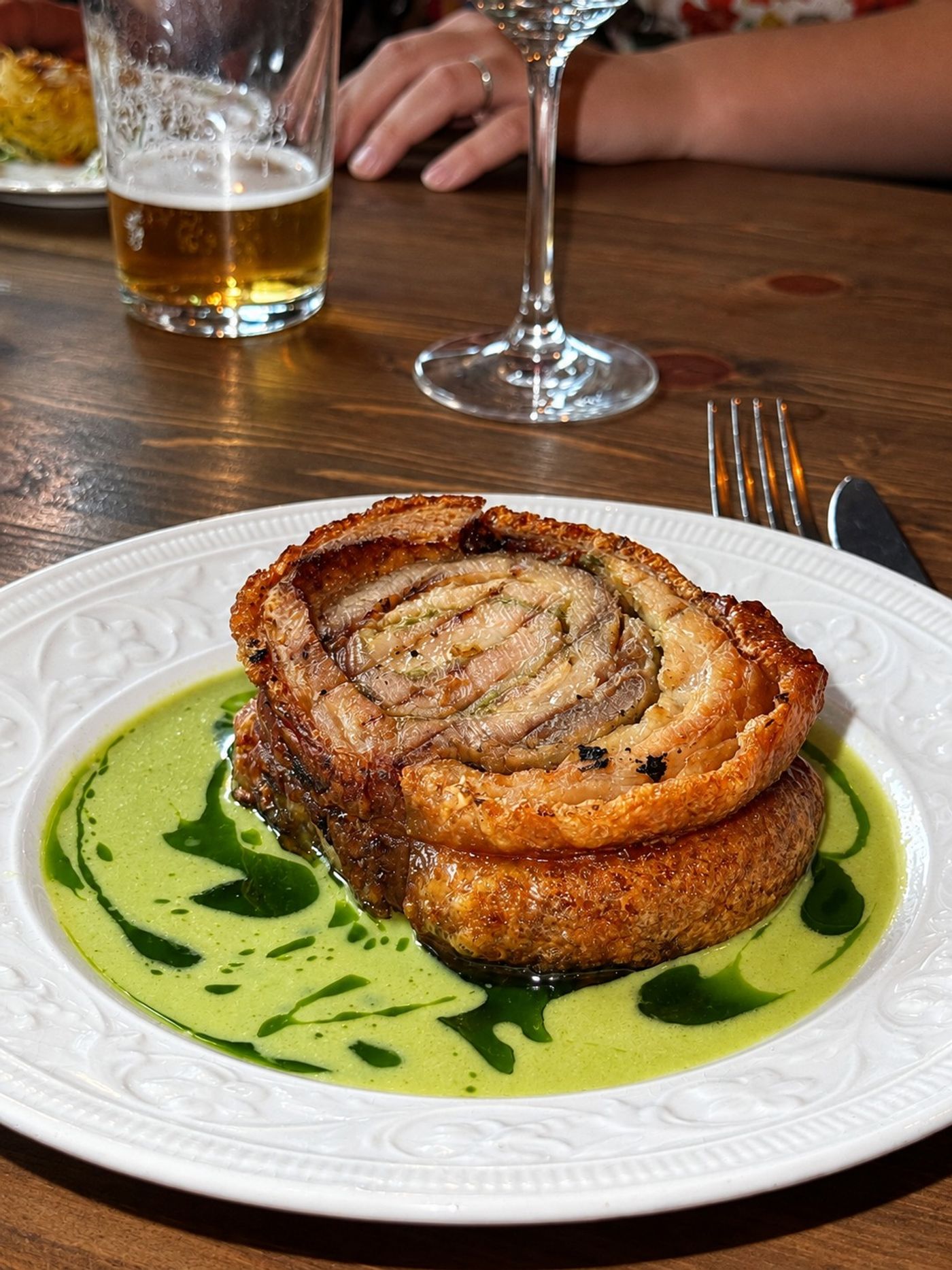 Rullad porchetta på örtolja med ett glas öl bredvid, Oss Emellan