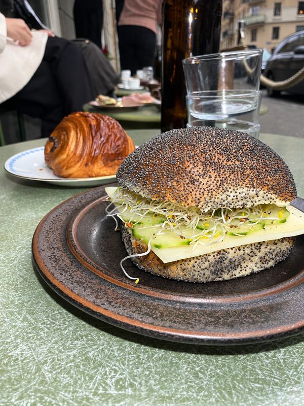 Fralla med vallmofrön, ost, gurka och groddar på keramiktallrik, Borgskogs