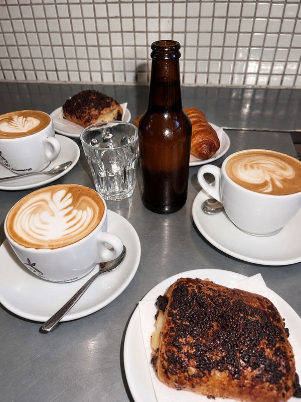Cappuccino med latte art och bakverk på ståbordet, Bar Centro