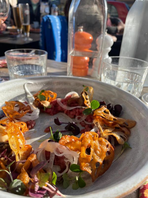 Råbiff med friterade rotfruktschips och örter på keramiktallrik, Jespers