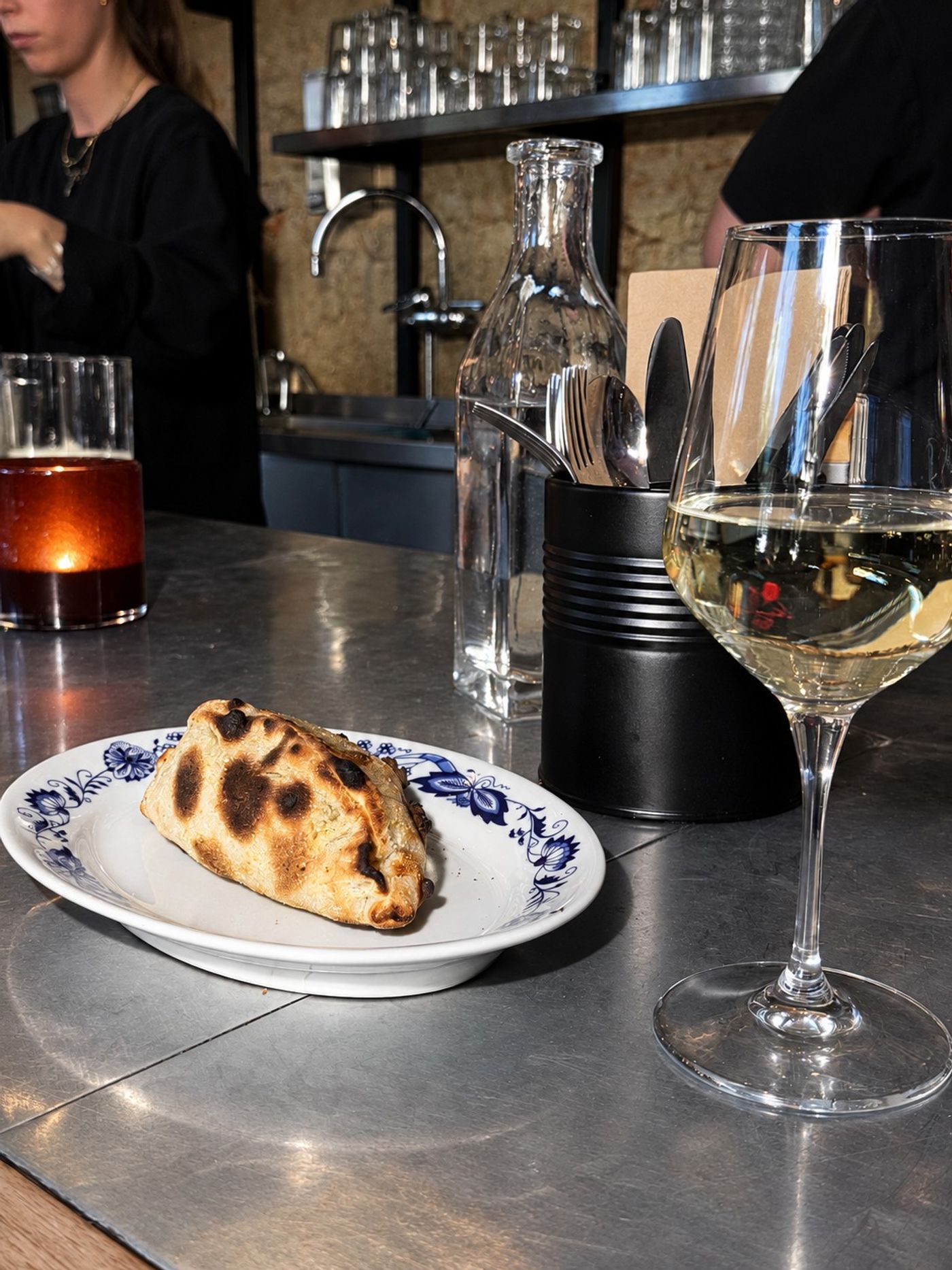 Calzone på blåmönstrat porslin vid bardisken, Bikt