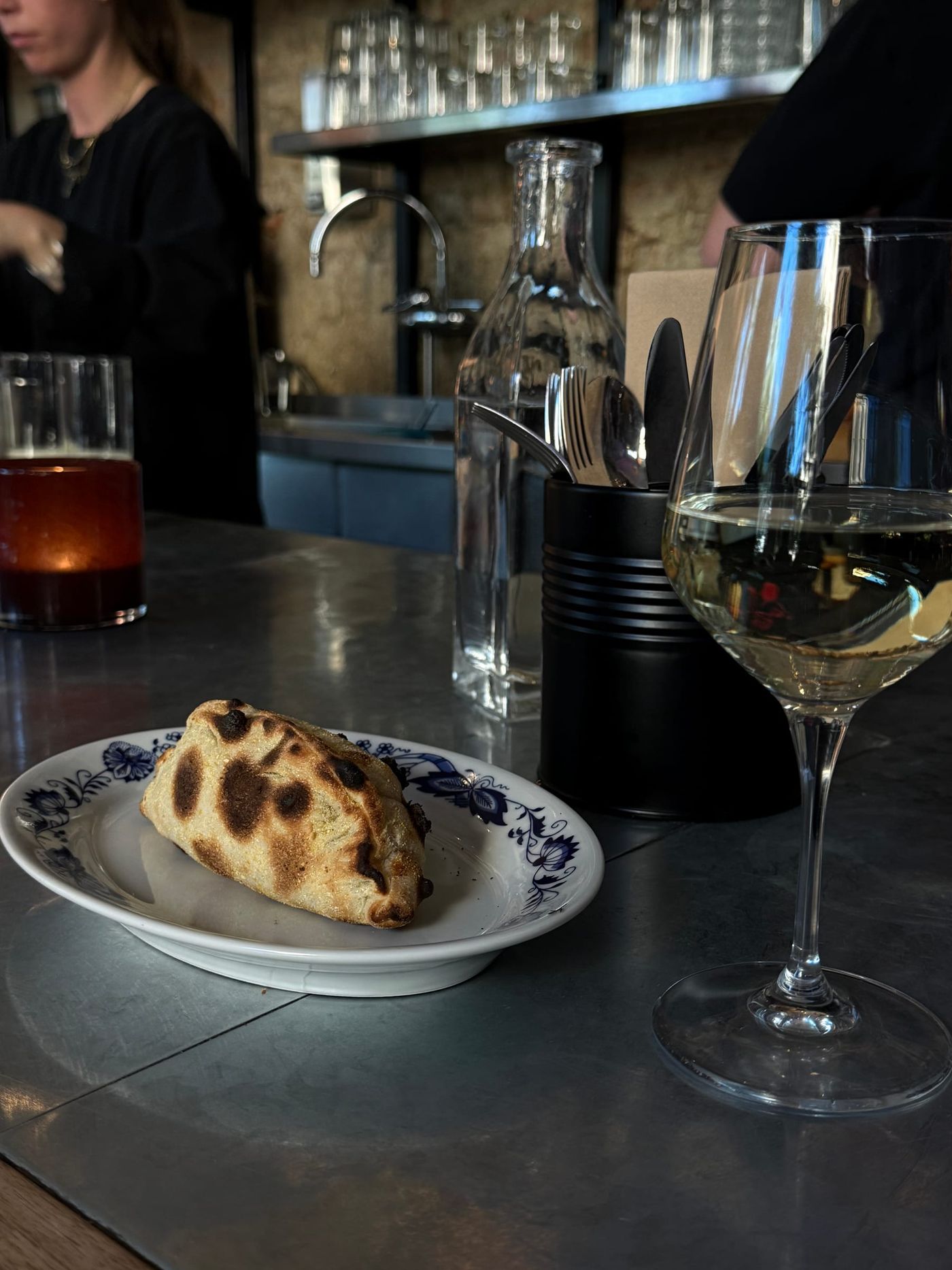 Calzone på blåmönstrat porslin vid bardisken, Bikt