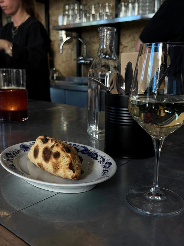 Calzone på blåmönstrat porslin vid bardisken, Bikt