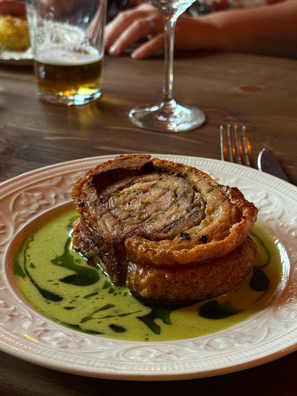 Rullad porchetta på örtolja med ett glas öl bredvid, Oss Emellan