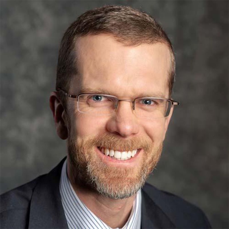 headshot of Speaker 1