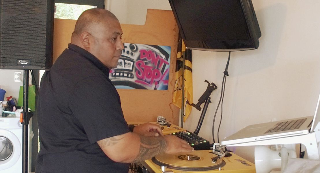 A man standing at a DJ set up