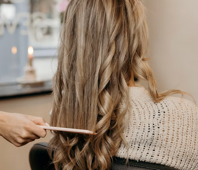 Lang golvend blond haar wordt geborsteld