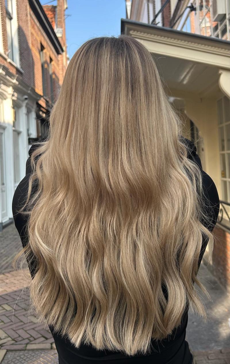 Lang golvend blond haar wordt geborsteld