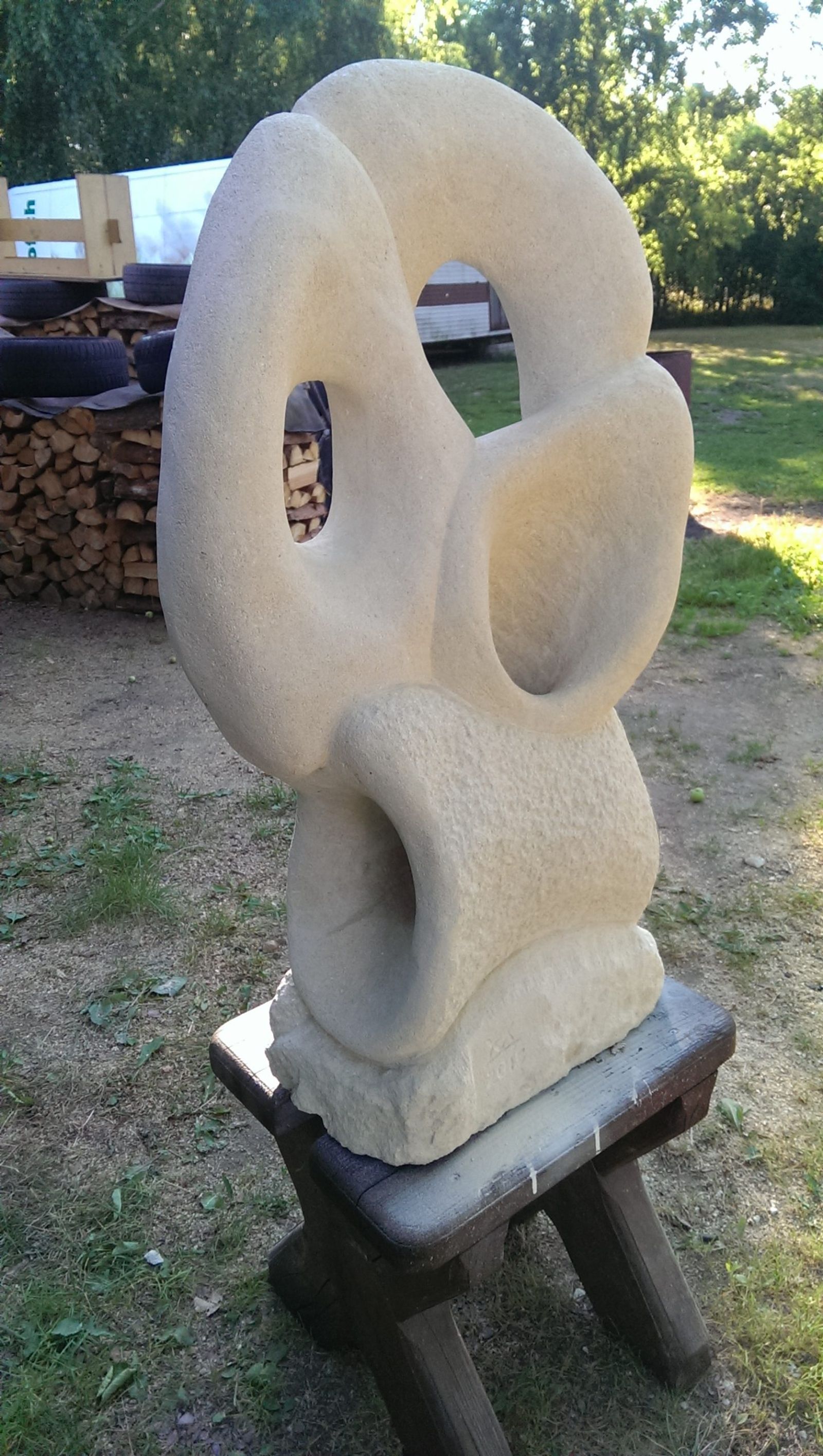 Carved stone sculpture with looping, folded openings, outdoors