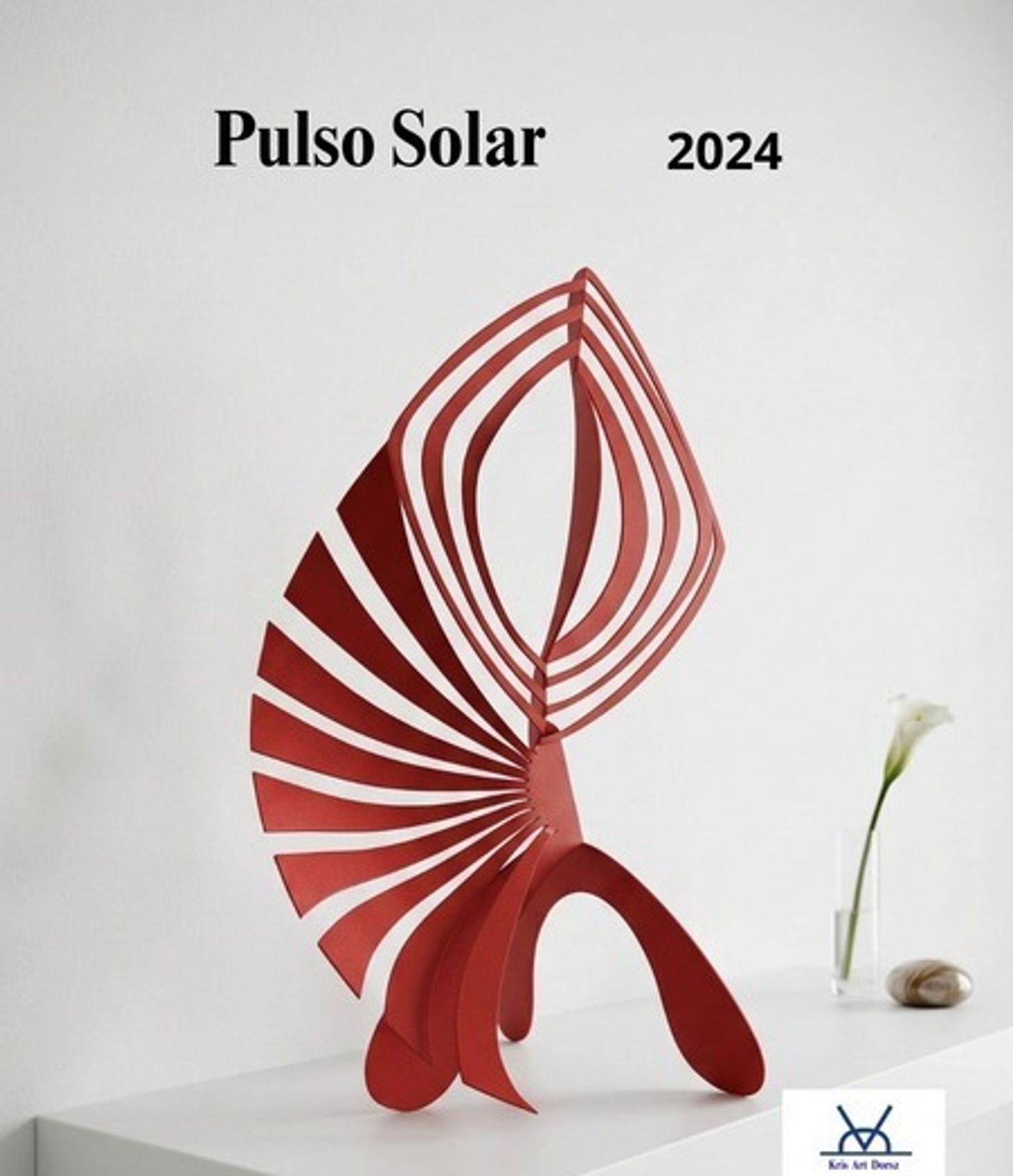 Pulso Solar, a painted iron sculpture staged on a white console table beside a calla lily