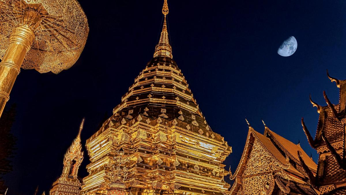 A golden temple and glowing night-market lanterns in Chiang Mai, Thailand