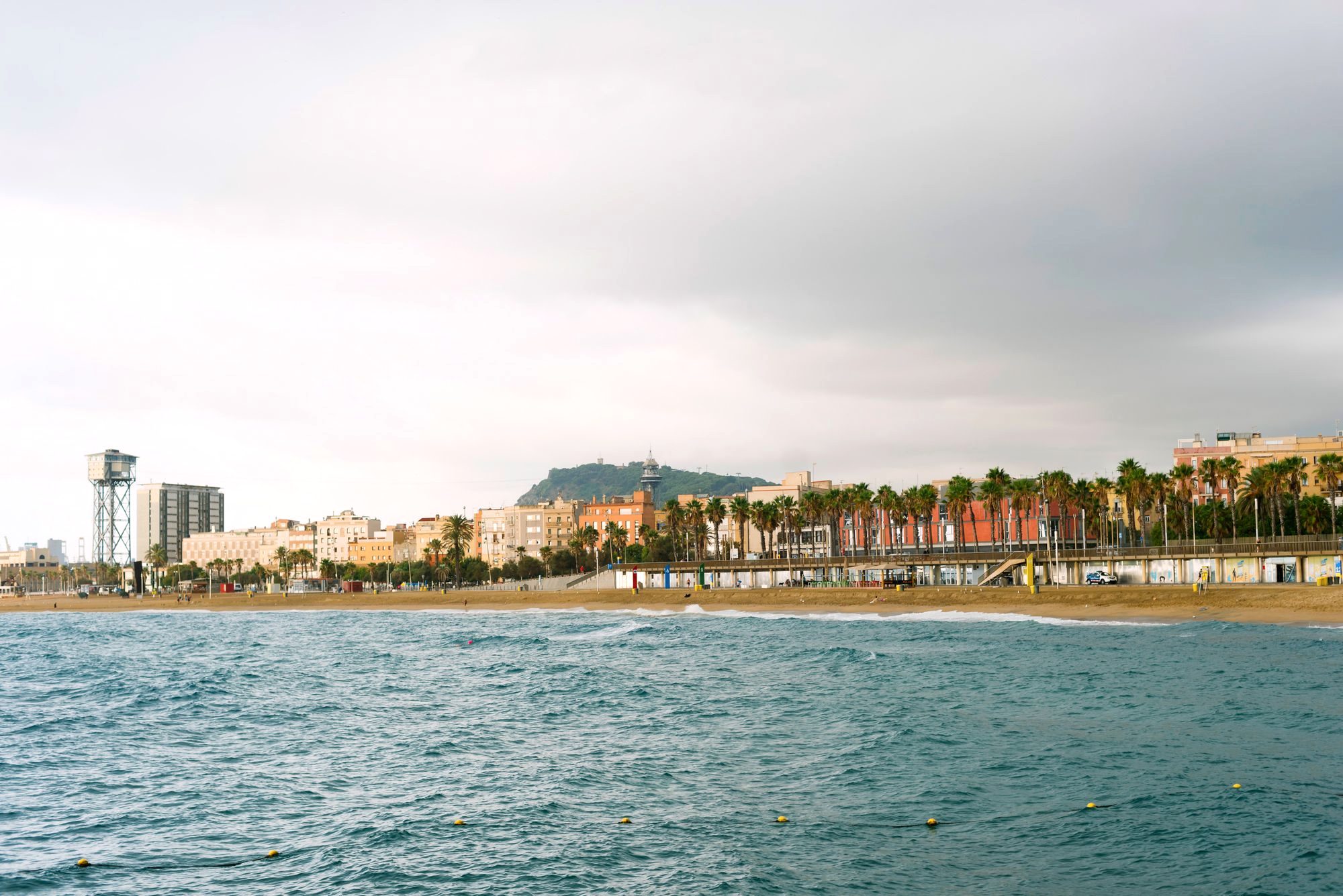 The palm-lined Barceloneta beach and promenade at sunset in Barcelona