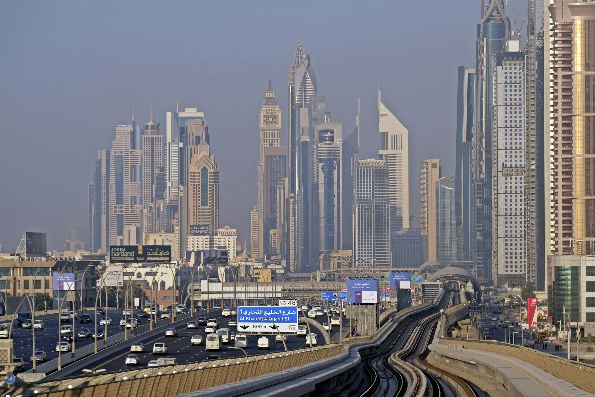 A driverless Dubai Metro train gliding on elevated track past the skyline