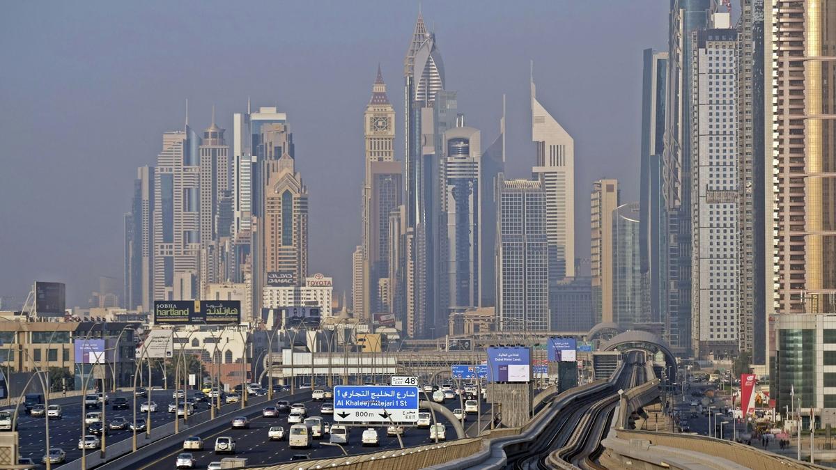 A driverless Dubai Metro train gliding on elevated track past the skyline