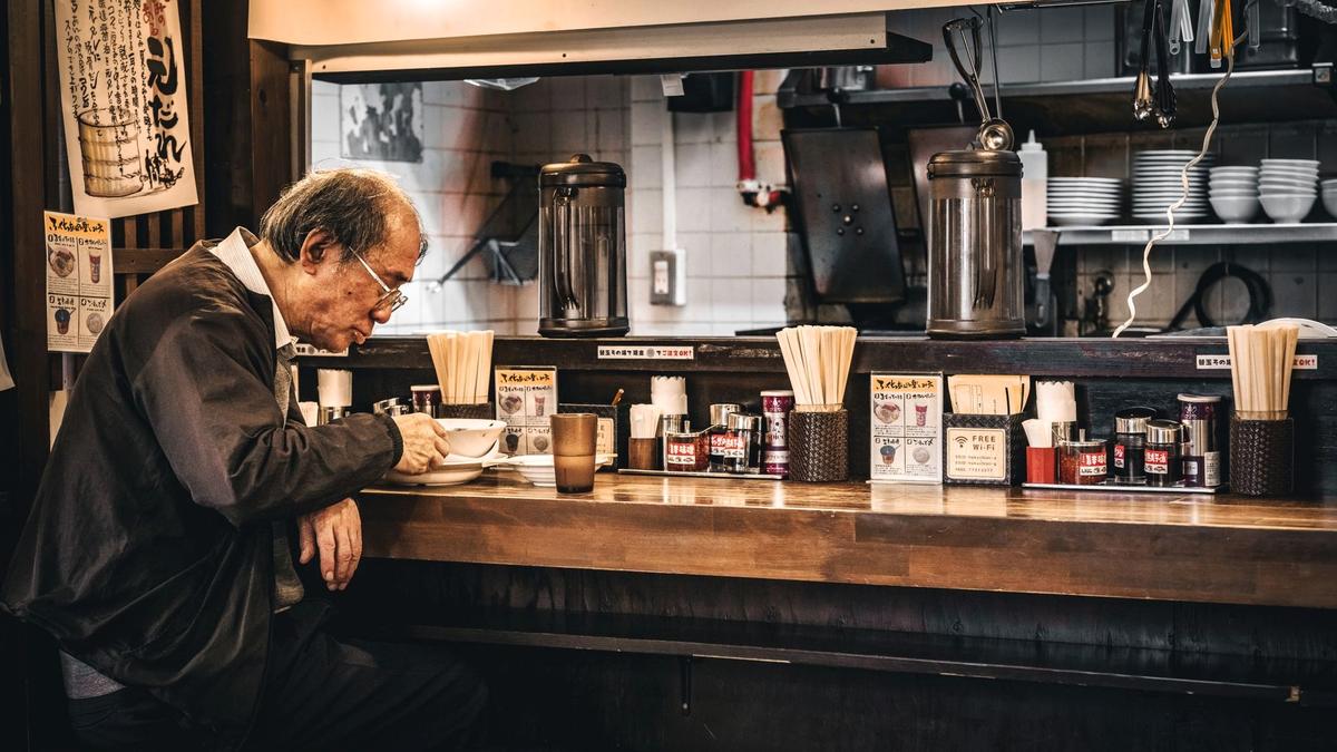 A steaming bowl of tonkotsu ramen at a small counter shop in Tokyo