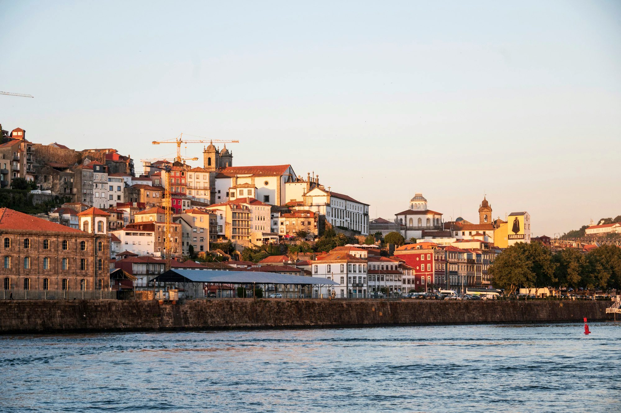 Colorful houses stacked above the Douro River in Porto, an underrated Portuguese city