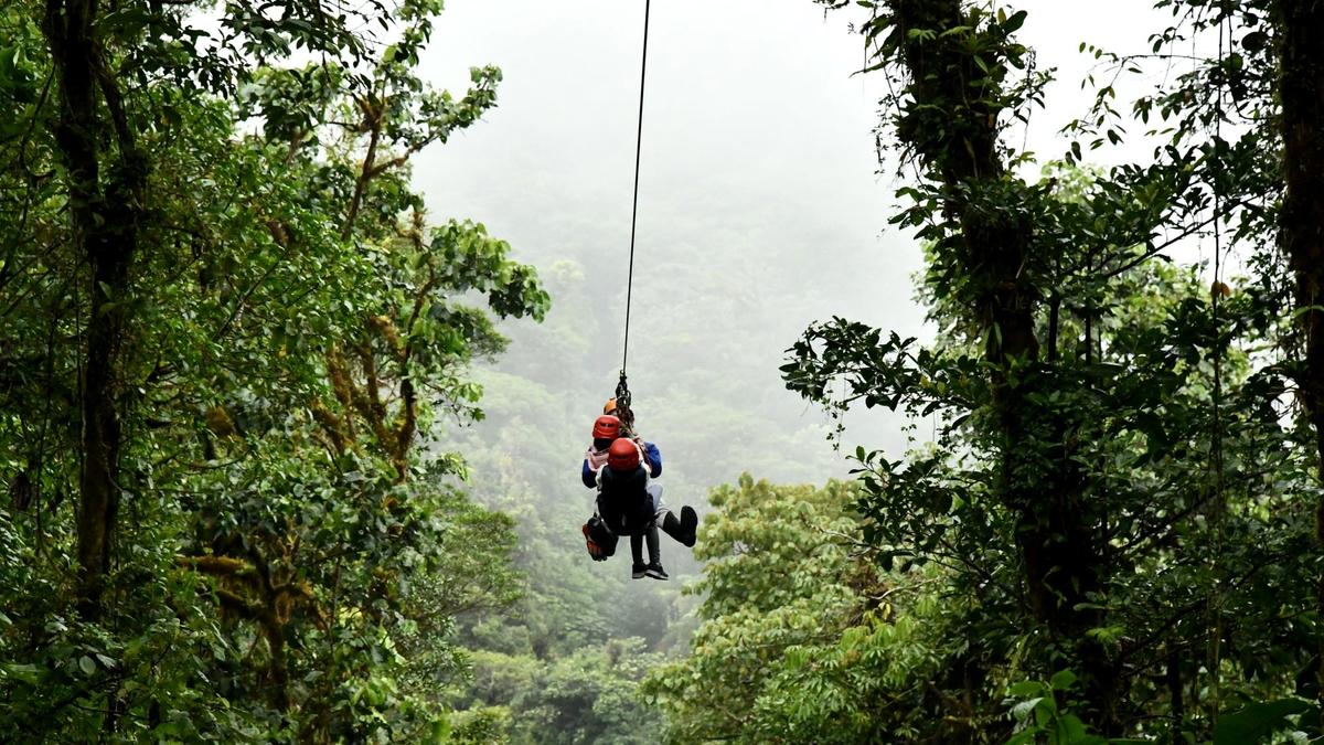 A traveler zip-lining over the rainforest canopy in Costa Rica
