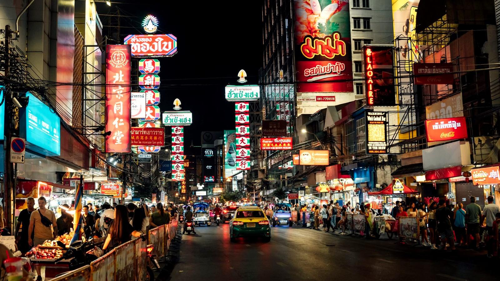 Steam and neon over crowded street food stalls on Yaowarat Road in Bangkok's Chinatown at night