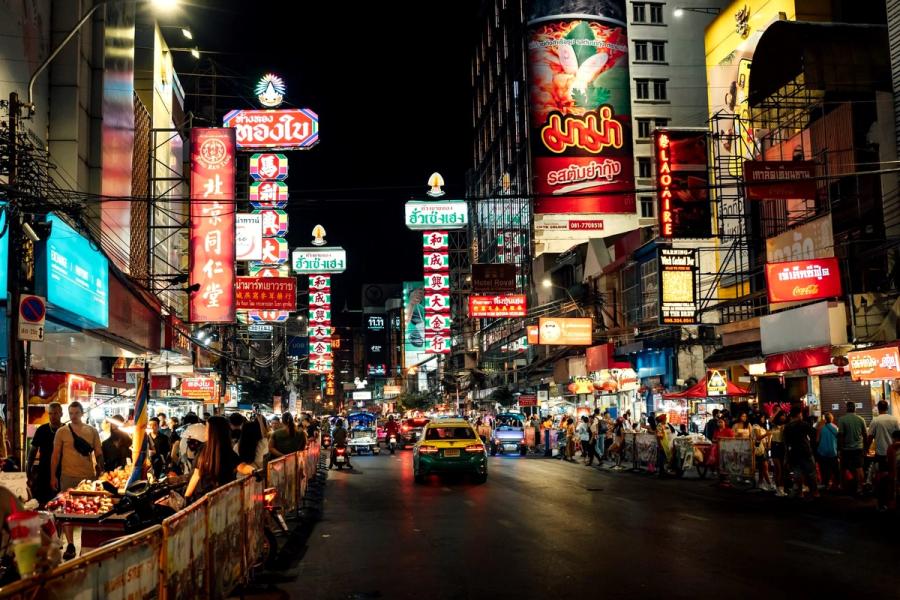 Steam and neon over crowded street food stalls on Yaowarat Road in Bangkok's Chinatown at night