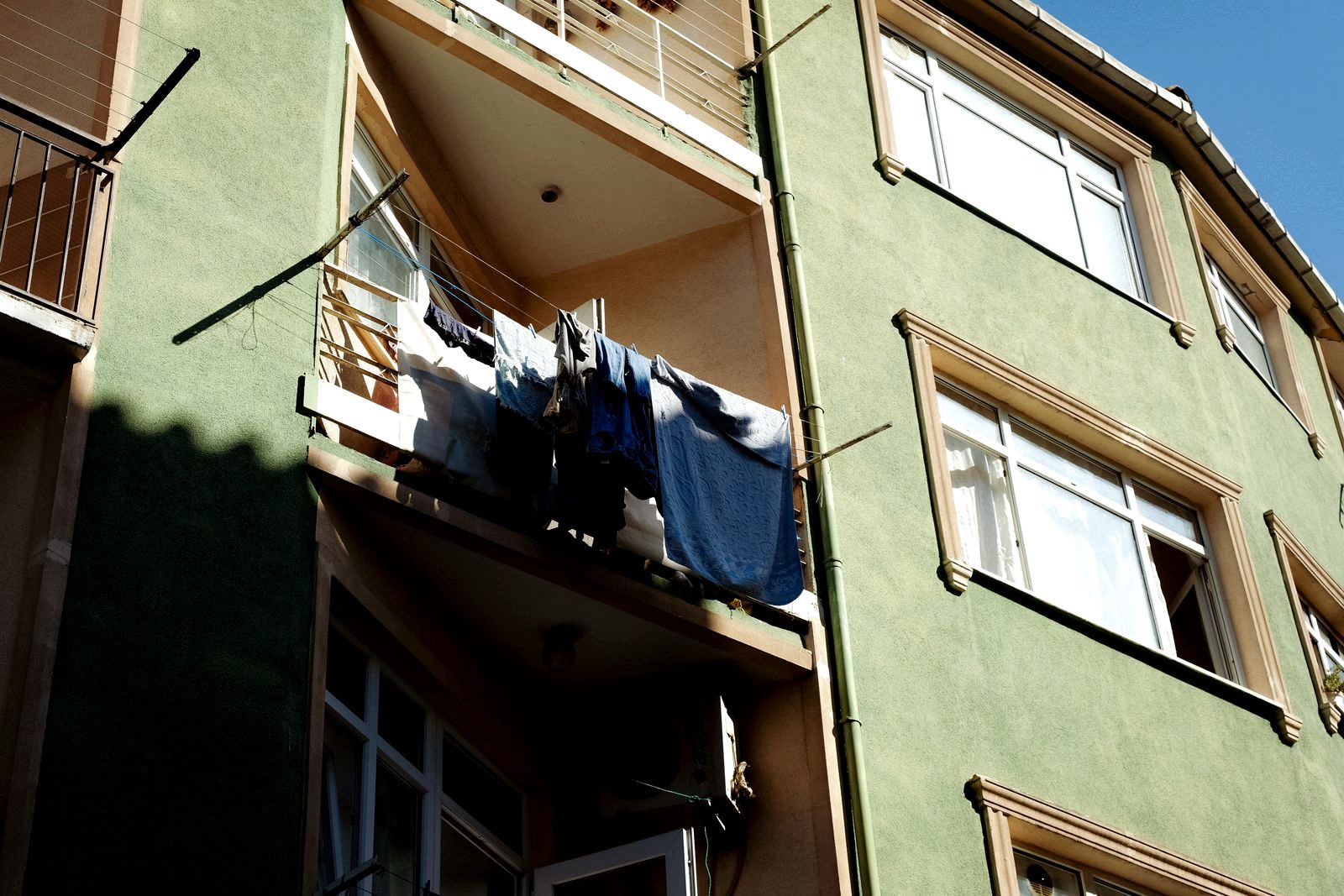 Freshly washed travel clothes hanging out to dry on a sunny balcony line
