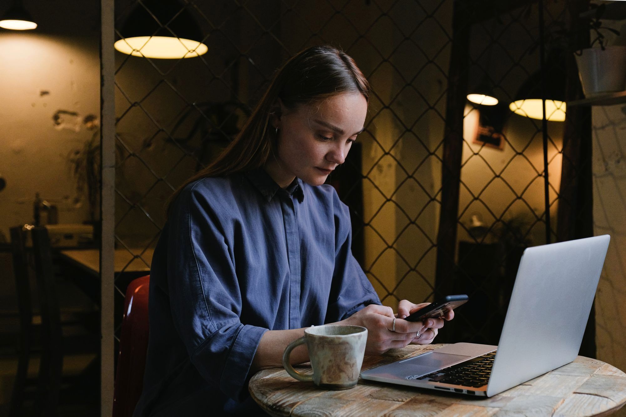 Traveler working on a phone and laptop in a cafe while abroad