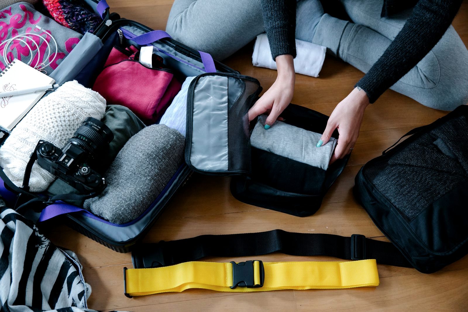 Mesh packing cubes filled with rolled clothes being packed into a carry-on