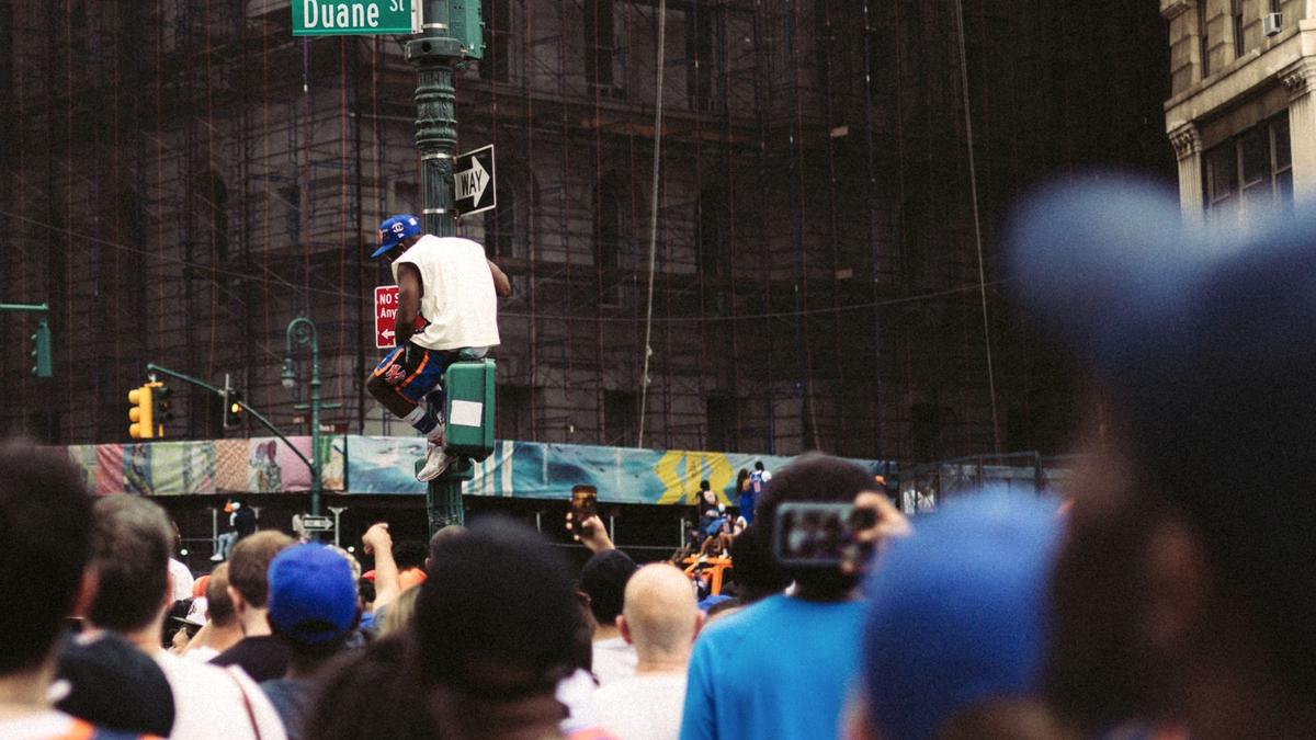 Crowds crossing a busy Manhattan avenue in New York City