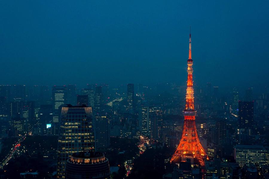 Neon-lit Tokyo skyline at night with crowded streets and glowing signs