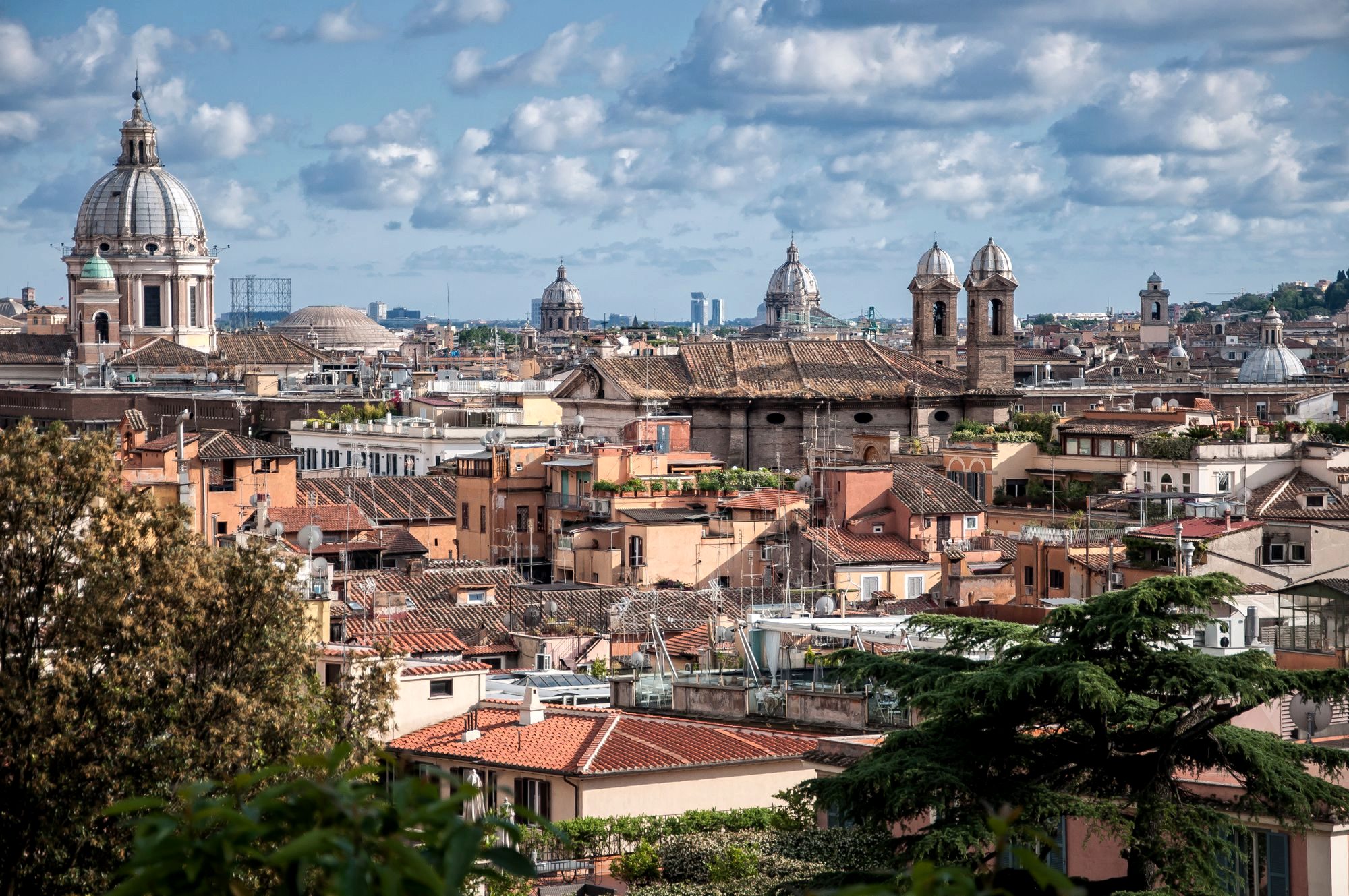 Terracotta rooftops and domes across central Rome, the walkable core around Monti