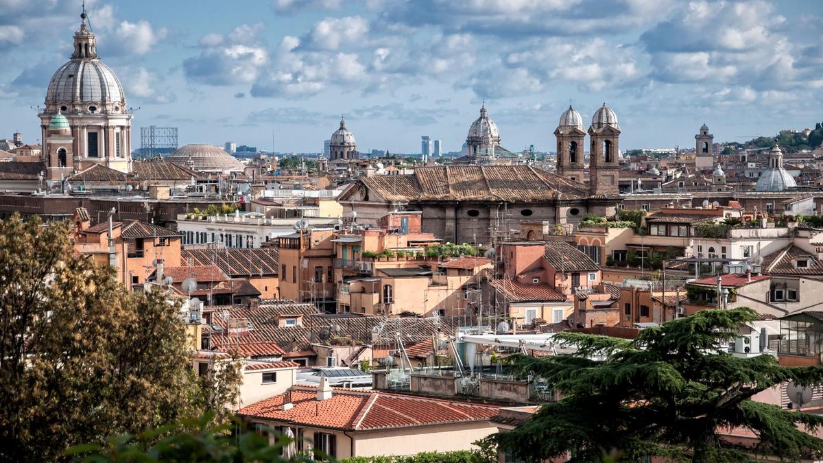 Terracotta rooftops and domes across central Rome, the walkable core around Monti