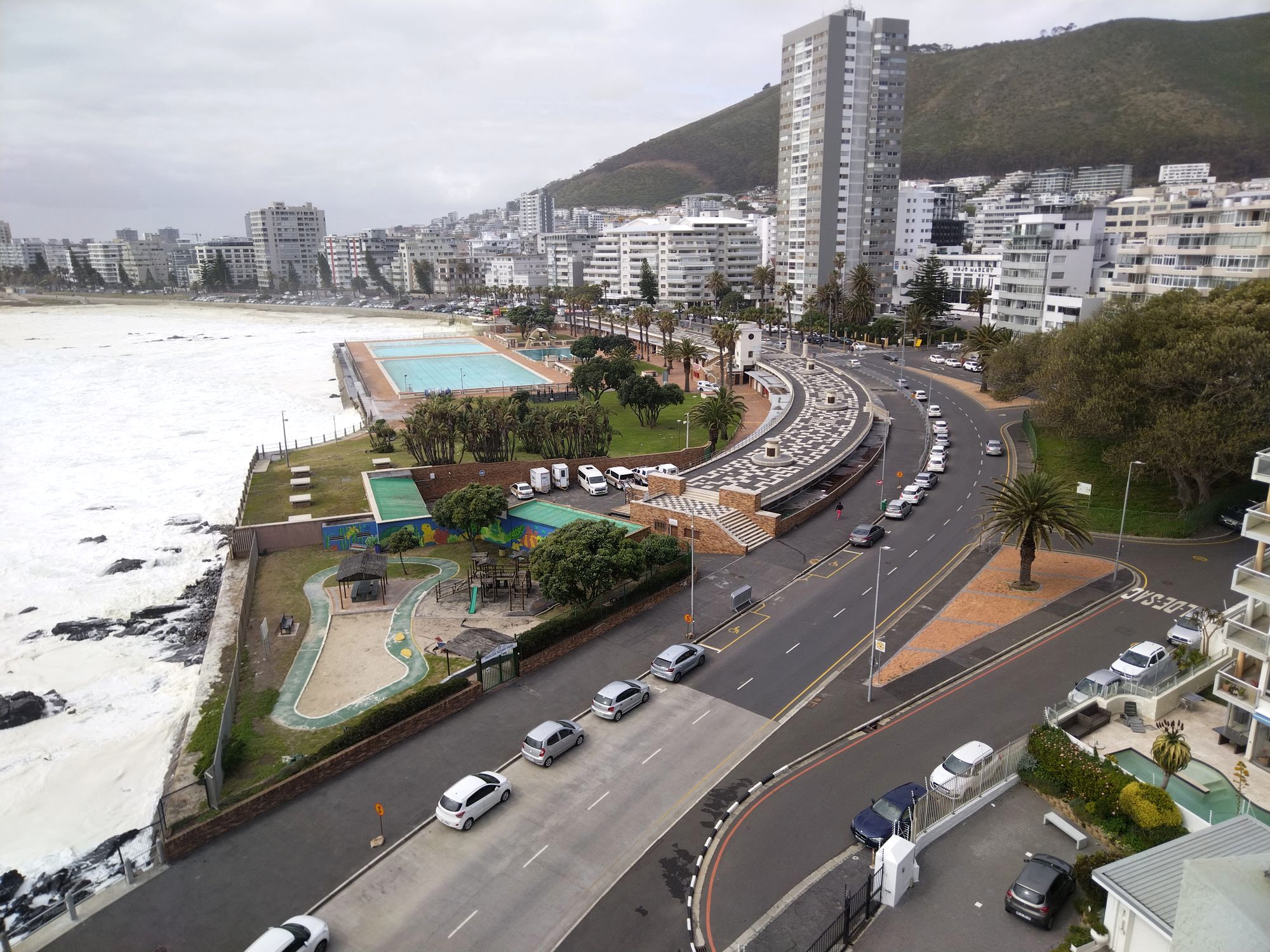 A rental car on a scenic coastal road below the mountains near Cape Town
