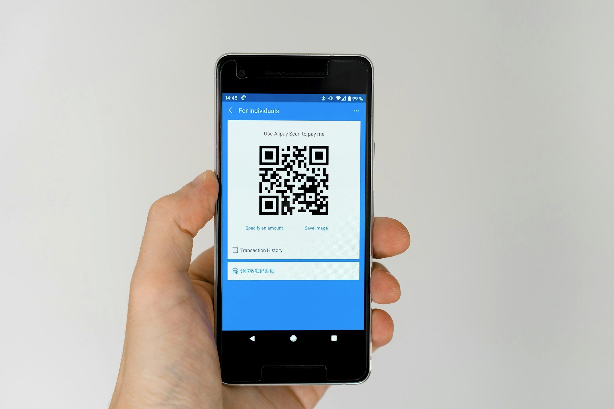 Traveler holding a phone showing a QR code to activate a mobile plan