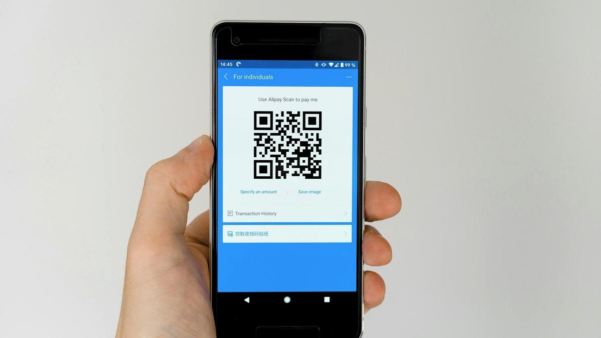 Traveler holding a phone showing a QR code to activate a mobile plan