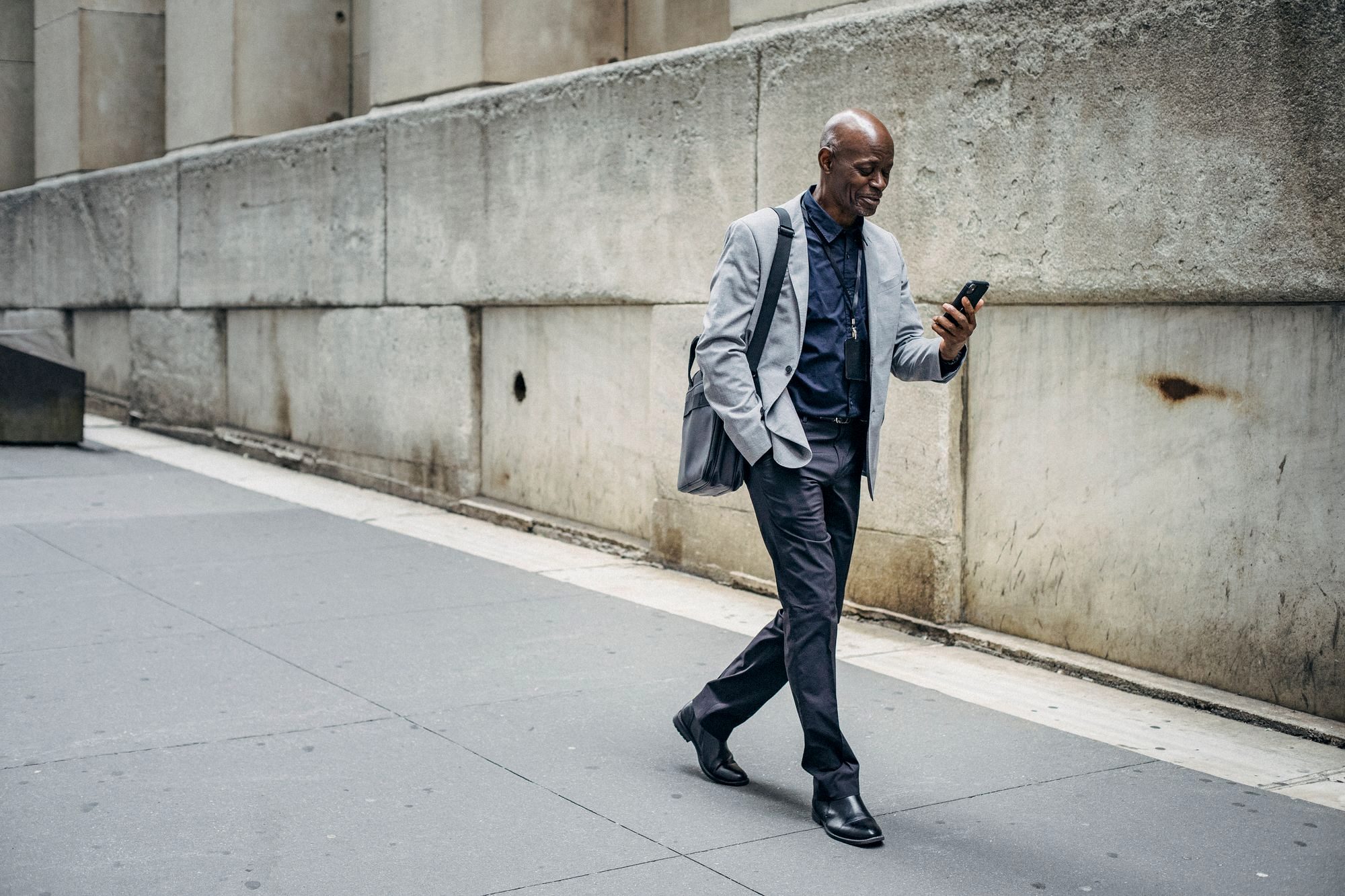 A traveler holding a smartphone with full signal bars on a busy foreign-city street