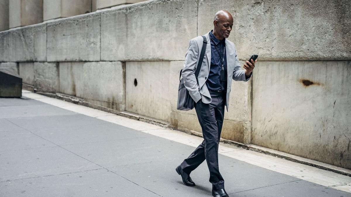 A traveler holding a smartphone with full signal bars on a busy foreign-city street