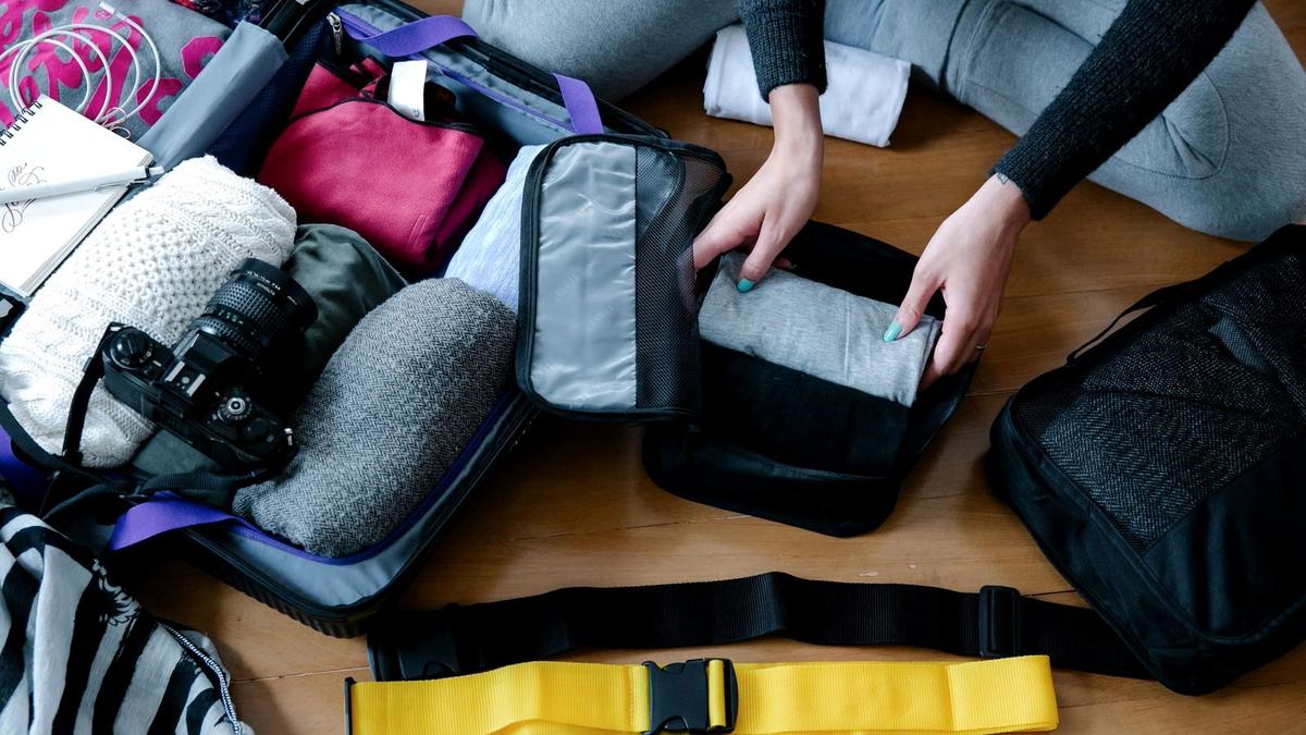 Mesh packing cubes filled with rolled clothes being packed into a carry-on